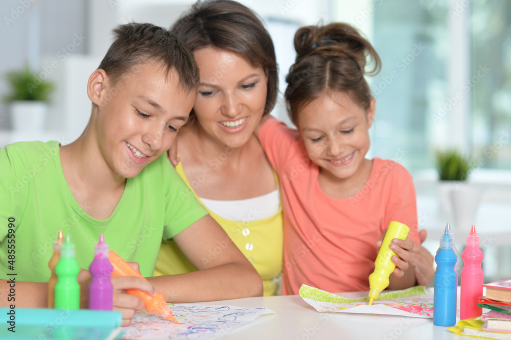 Smiling mother, brother and sister drawing together Smiling mother, brother and sister drawing together