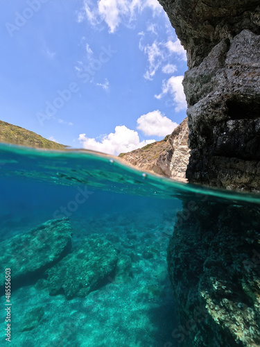 Fototapeta Naklejka Na Ścianę i Meble -  Underwater split photo of beautiful paradise pebble rocky bay of Kaladi with turquoise crystal clear sea and small caves, Kythira island, Ionian, Greece