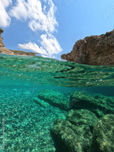 Underwater split photo of beautiful paradise pebble rocky bay of Kaladi with turquoise crystal clear sea and small caves, Kythira island, Ionian, Greece photo