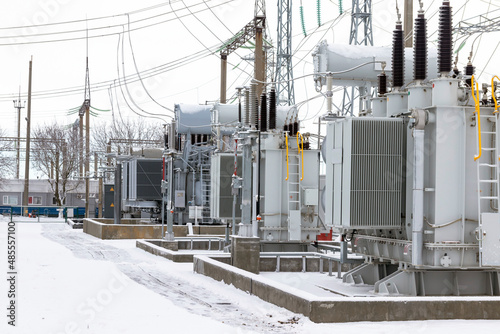 View of the electrical substation. An electrical substation with transformers distributing high voltage throughout the city. High voltage electrical substation in winter. © Алексей Кравчук