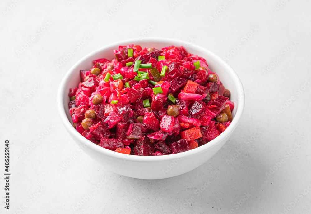 Salad vinaigrette with boiled vegetables, sauerkraut, cucumbers and peas on a light background. Salad vinaigrette with boiled vegetables, sauerkraut, cucumbers and peas on a light background.