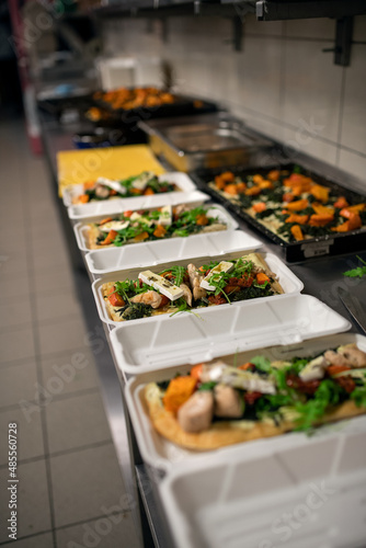 Meals in containers prepared for take away in kitchen restaurant.