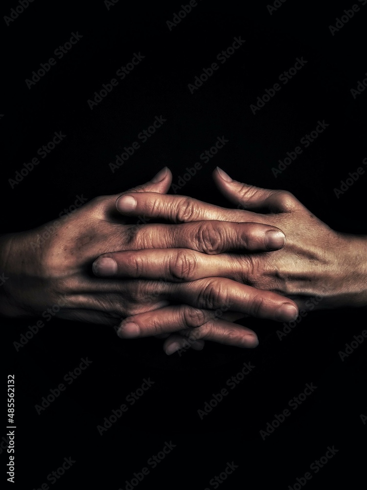 Fototapeta premium hands of the old person on black background with copy space
