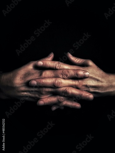 hands of the old person on black background with copy space