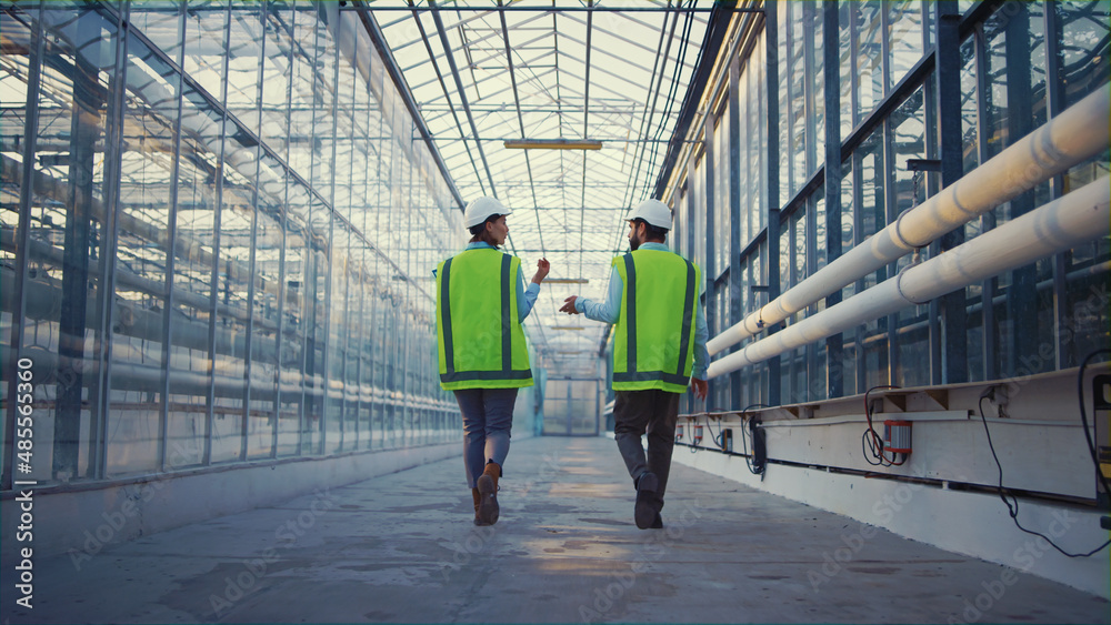 Portrait engineers walking in factory checking safety discussing production Portrait engineers walking in factory checking safety discussing production