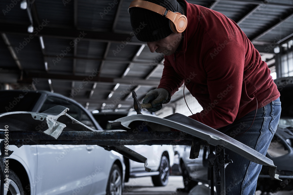 Car service worker repairs restores car