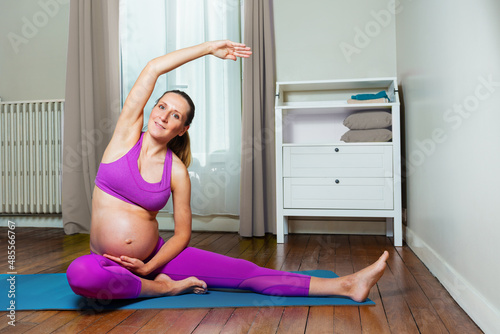 Pregnant woman do stretching exercise at home