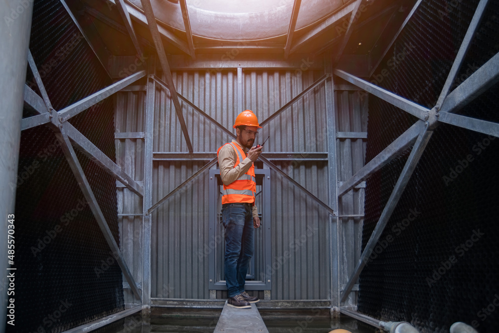 engineer under checking the industry cooling tower air conditioner is water cooling tower air chiller HVAC of large industrial building to control air system.