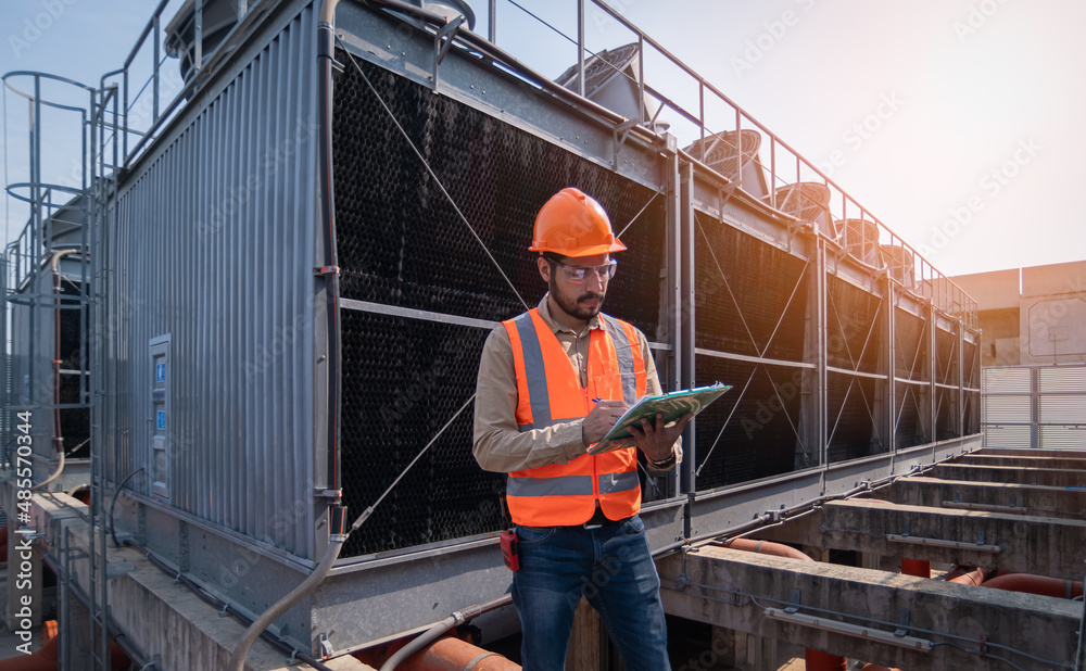 engineer under checking the industry cooling tower air conditioner is water cooling tower air chiller HVAC of large industrial building to control air system.