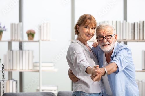 senior couple, elderly man and woman dancing together at home © offsuperphoto