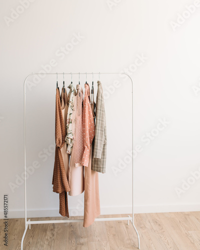 Rack with capsule clothes in beige and pink colors © Lisa