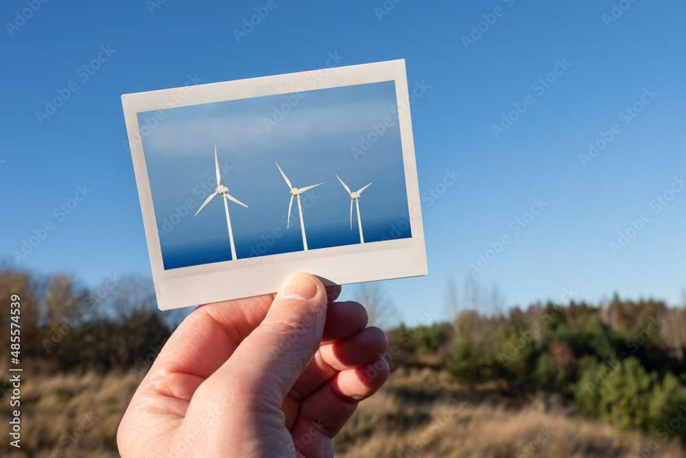 Hand holding photo of wind turbines Stock Photo | Adobe Stock
