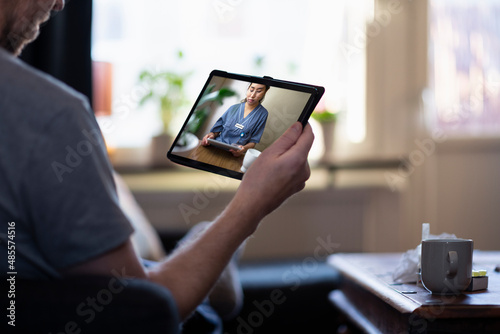 Man having online doctor consultation on digital tablet photo