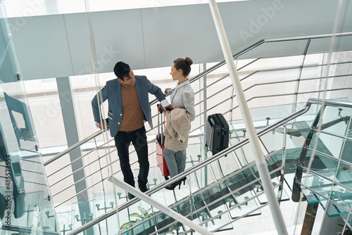 Tourist couple with luggage standing on glass stairs © Viacheslav Yakobchuk