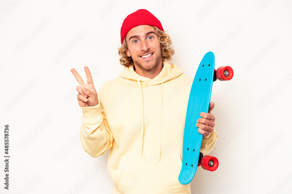 Young skater caucasian man isolated on white background joyful and carefree showing a peace symbol with fingers. Young skater caucasian man isolated on white background joyful and carefree showing a peace symbol with fingers.