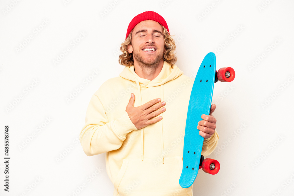 Young skater caucasian man isolated on white background laughs out loudly keeping hand on chest. Young skater caucasian man isolated on white background laughs out loudly keeping hand on chest.