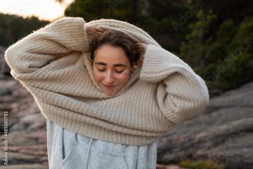 Woman putting jumper on photo