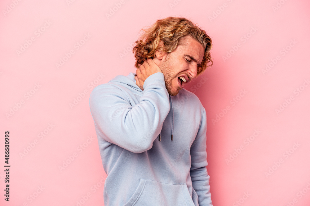 Young caucasian man isolated on pink background suffering neck pain due to sedentary lifestyle. Young caucasian man isolated on pink background suffering neck pain due to sedentary lifestyle.