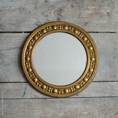 Mid-century modern copper framed mirror on a wooden boards