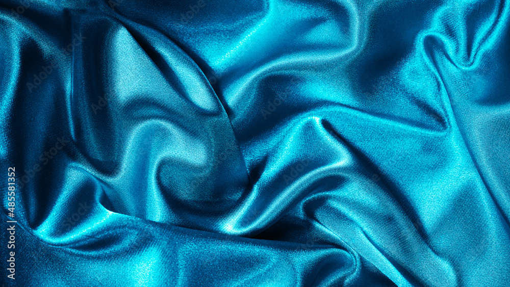 Obraz premium Light blue silk satin. Folds on shiny fabric surface. Beautiful teal background with space for design