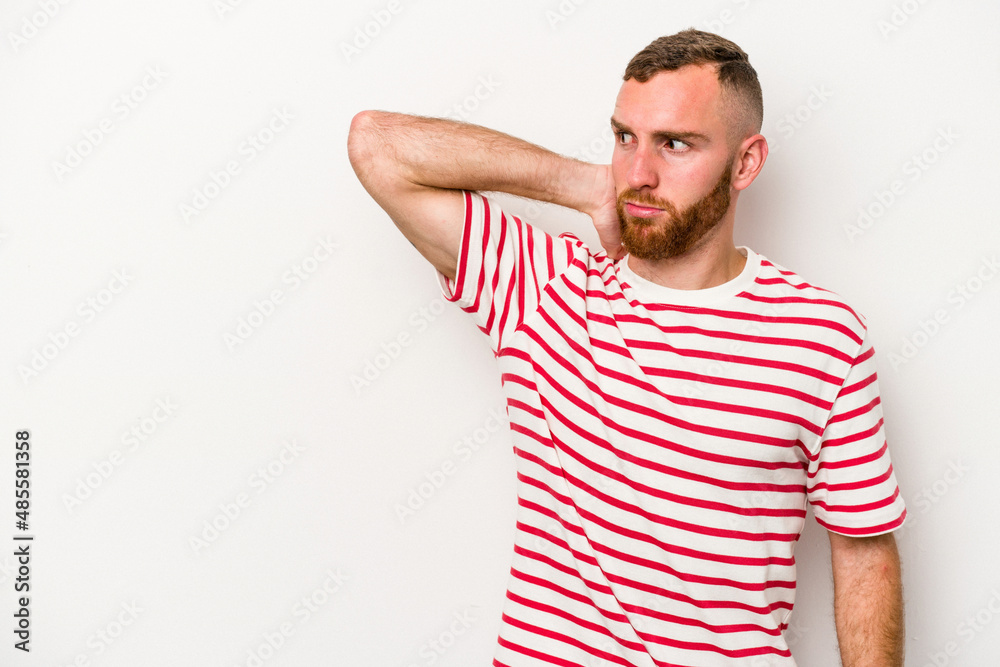Young caucasian man isolated on white background touching back of head, thinking and making a choice. Young caucasian man isolated on white background touching back of head, thinking and making a choice.