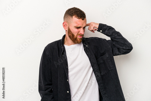 Young caucasian man isolated on white background covering ears with hands.