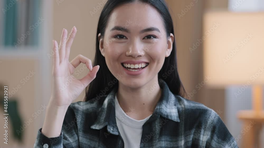 Female portrait happy recommending smiling winner asian woman girl showing ok gesture everything fine sign success good news done consent victory symbol folding fingers zero looking at camera at home Female portrait happy recommending smiling winner asian woman girl showing ok gesture everything fine sign success good news done consent victory symbol folding fingers zero looking at camera at home