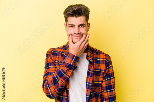 Wallpaper Mural Young caucasian man isolated on yellow background doubting between two options. Torontodigital.ca