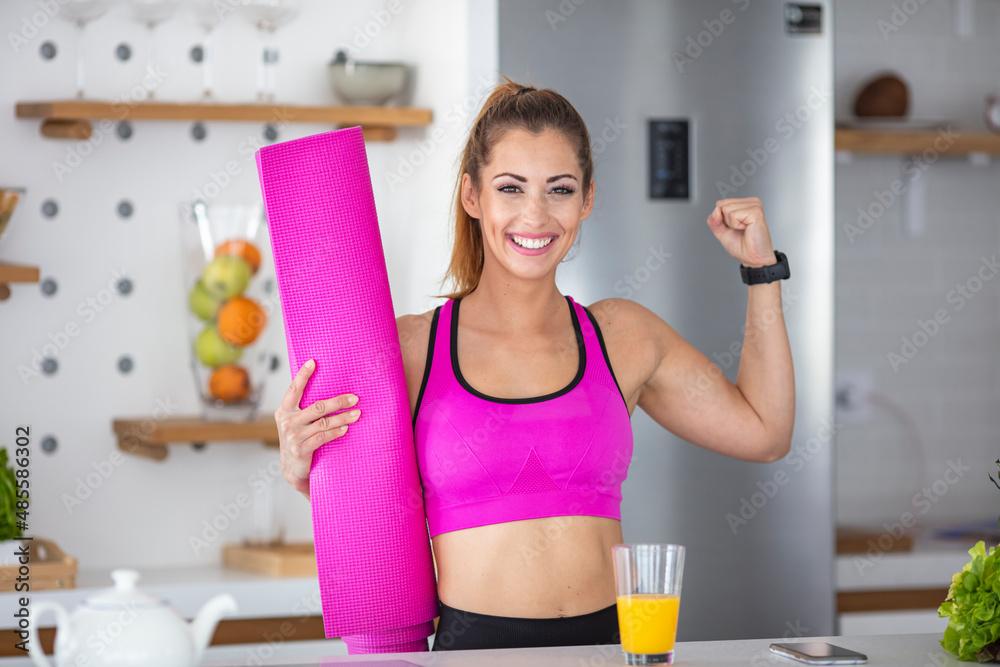 Young, strong sports, athletic fitness trainer instructor woman in fitness tracksuit drinks water bottle, shows arm muscles, biceps, drinks juice at home gym indoors Training Concept.