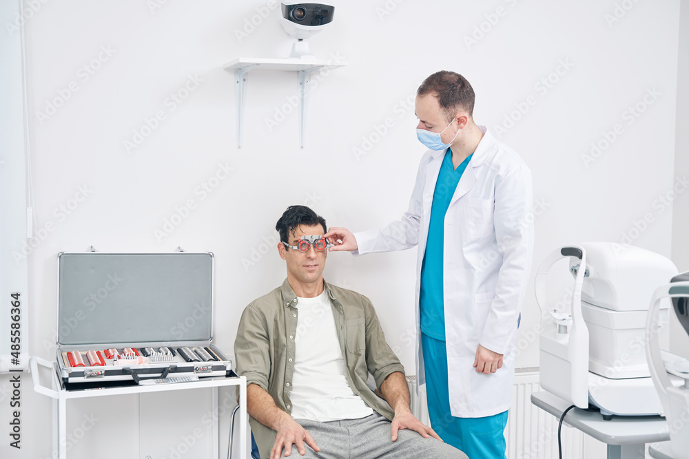 Professional ophthalmologist diagnosing vision of man at the hospital