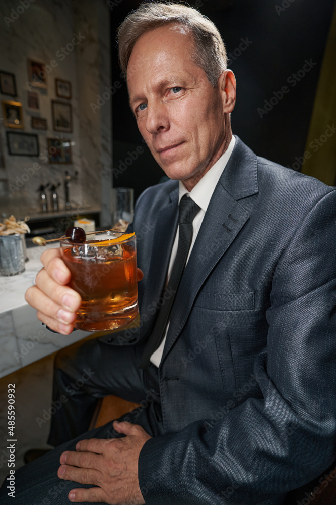 Elegant gentleman enjoying his beverage at the bar Elegant gentleman enjoying his beverage at the bar