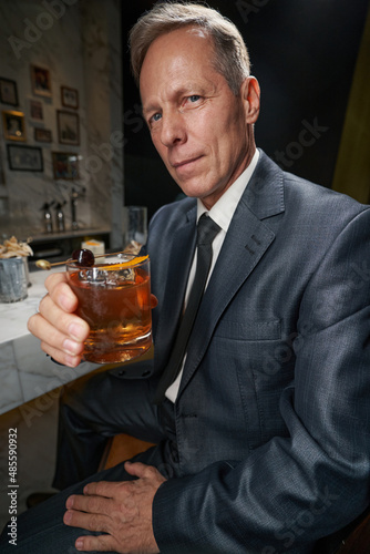 Elegant gentleman enjoying his beverage at the bar