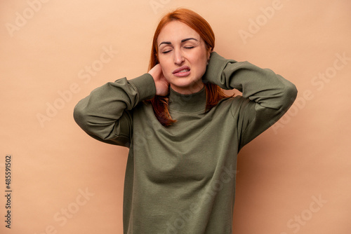 Young caucasian woman isolated on beige background suffering neck pain due to sedentary lifestyle. © Asier