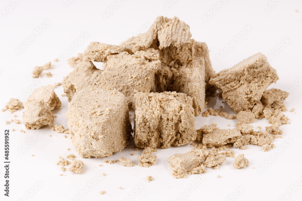 a large pile of halva with crumbs on a white background a large pile of halva with crumbs on a white background
