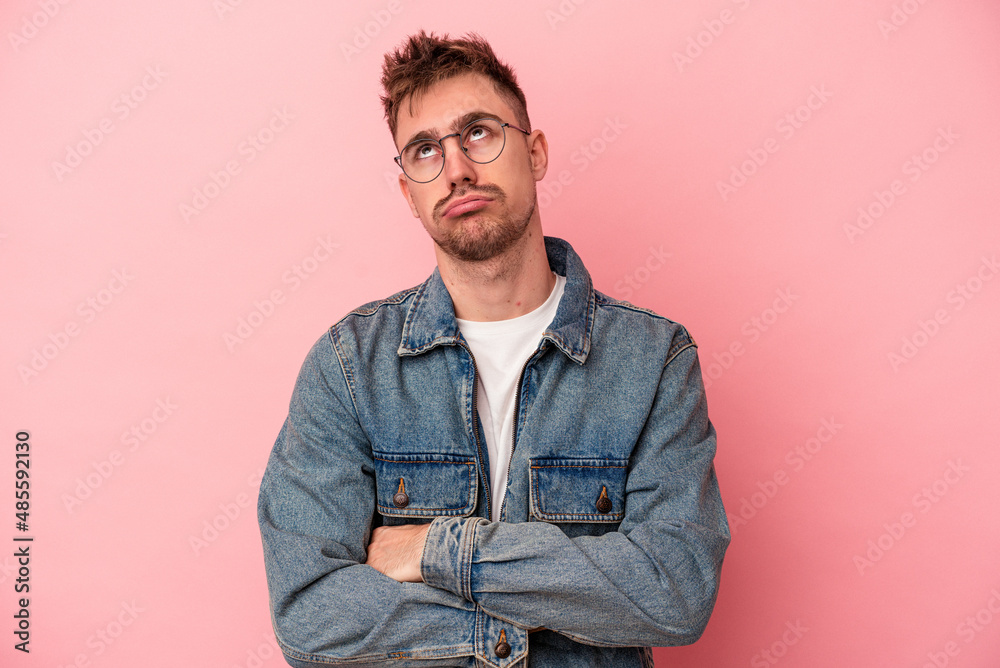 Young caucasian man isolated on pink background tired of a repetitive task. Young caucasian man isolated on pink background tired of a repetitive task.