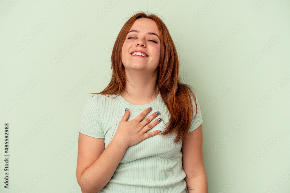 Young caucasian woman isolated on green background laughs out loudly keeping hand on chest. Young caucasian woman isolated on green background laughs out loudly keeping hand on chest.