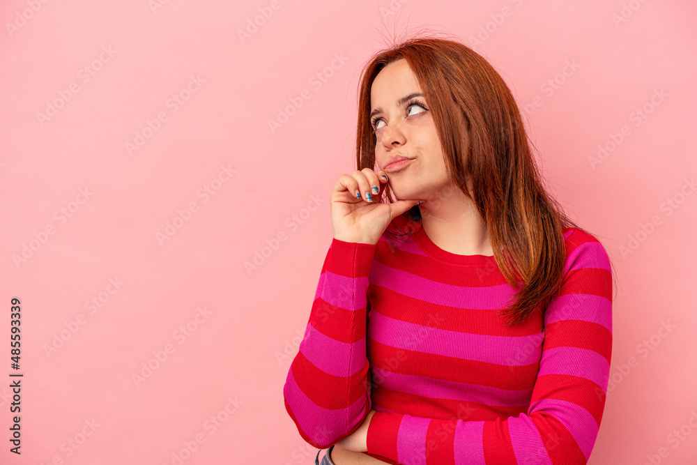 Young caucasian woman isolated on pink background looking sideways with doubtful and skeptical expression. Young caucasian woman isolated on pink background looking sideways with doubtful and skeptical expression.