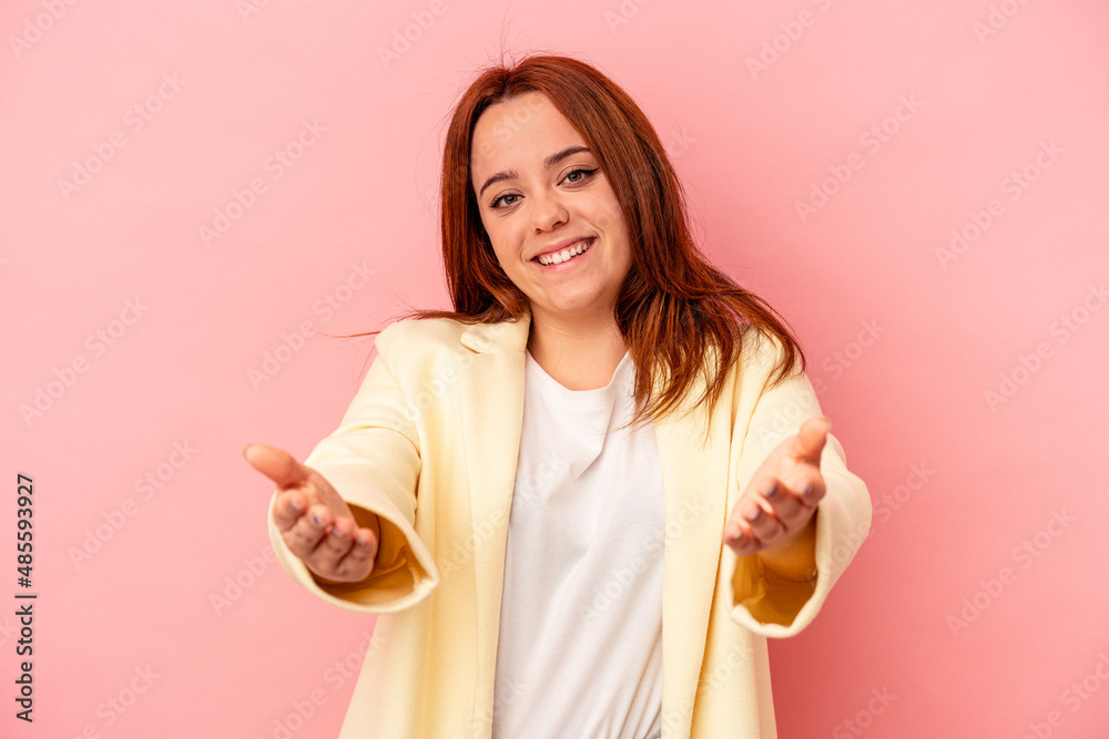 Young caucasian woman isolated on pink background showing a welcome expression. Young caucasian woman isolated on pink background showing a welcome expression.