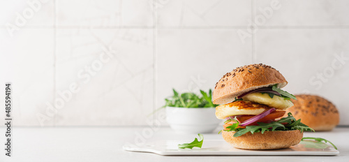 Halloumi burger with tomato, arugula and red onion. Sandwich with halloumi cheese and vegetables, mediterranean cuisine photo