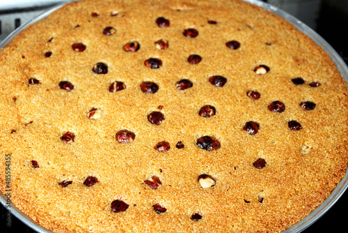 A tray of basbosa with hazelnut and honey sugary syrup on it, Basbusa is a middle eastern dessert that is usually baked in Ramadan month, selective focus of  Arabian sweet cuisine, selective focus photo