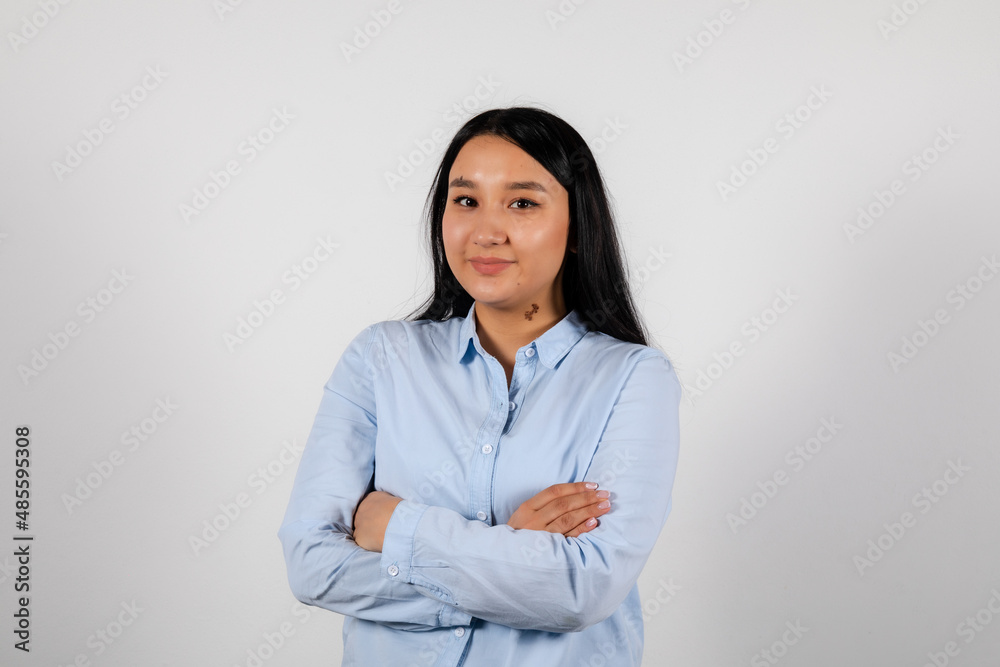 Portrait of a smiling young asian woman crossed hands in a blue shirt Portrait of a smiling young asian woman crossed hands in a blue shirt