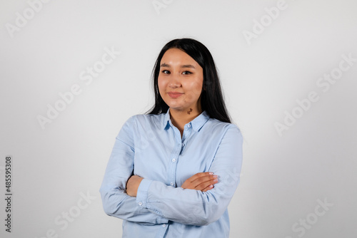 Portrait of a smiling young asian woman crossed hands in a blue shirt