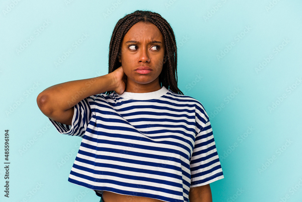 Young african american woman isolated on blue background touching back of head, thinking and making a choice. Young african american woman isolated on blue background touching back of head, thinking and making a choice.