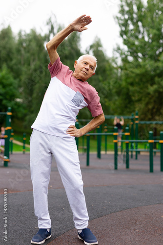 Active senior man is exercising in summer park. Healthy retirement lifestyle