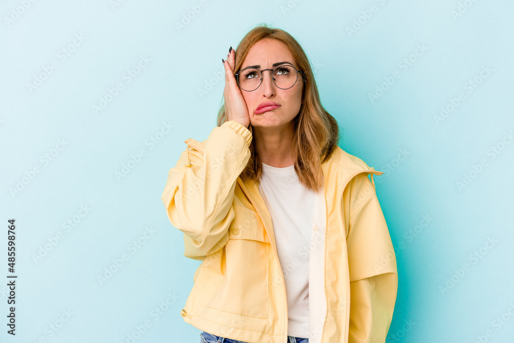 Young caucasian woman isolated on blue background tired and very sleepy keeping hand on head. Young caucasian woman isolated on blue background tired and very sleepy keeping hand on head.