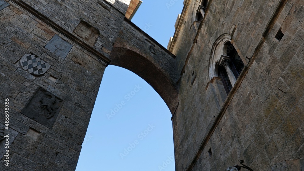 An arch between two ancient historic buildings in the city center of Volterra in Tuscany, Italy.
