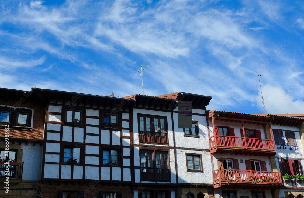 Vintage buildings decorated with wood in the old center of Hondarribia, Basque country, Spain. Houses with balconies backlit by sun