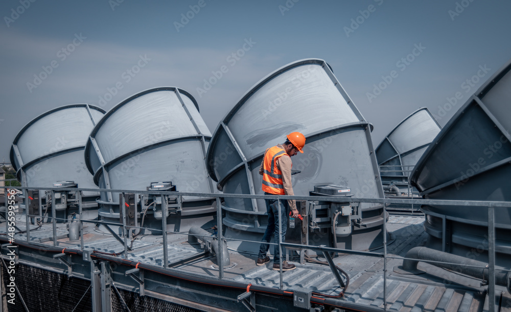 engineer under checking the industry cooling tower air conditioner is water cooling tower air chiller HVAC of large industrial building to control air system.