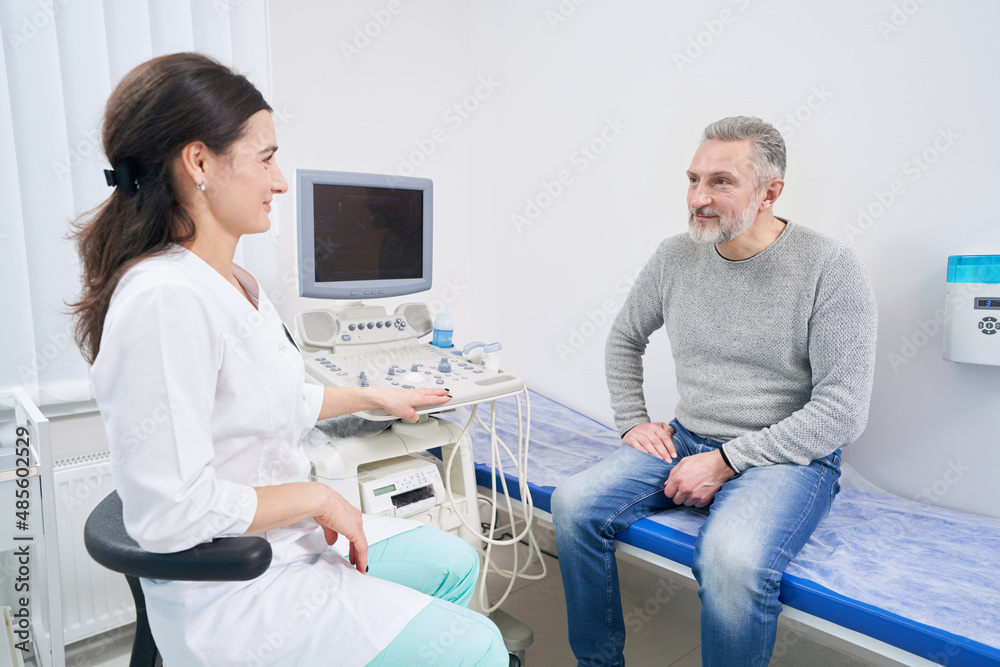 Obraz premium Male patient looking at sonographer before ultrasound scan