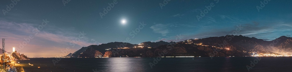 Night shot with moon and stars over lake Garda in Italy